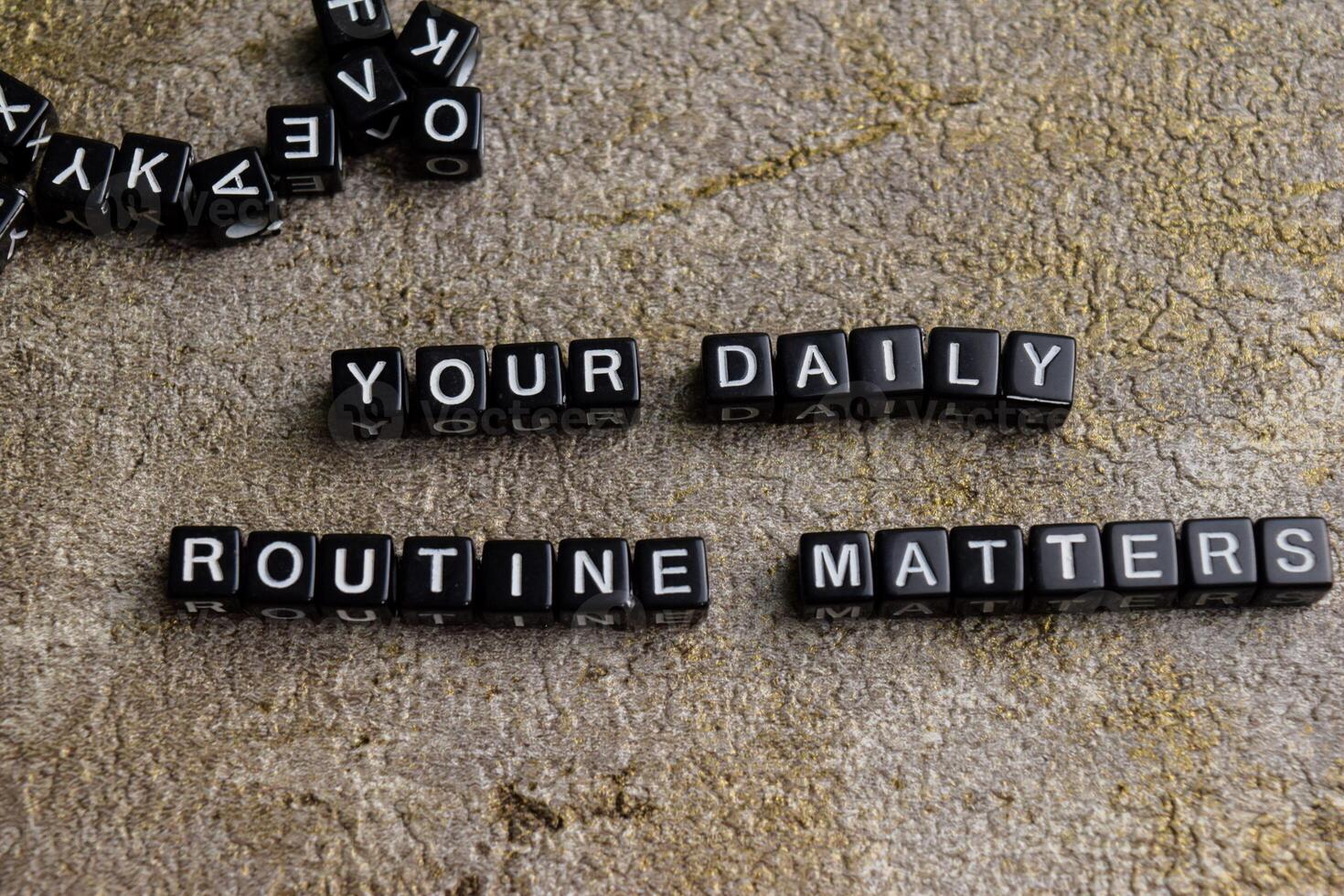 Concept of Your Daily Routine Matters written on wooden blocks. Cross processed image on Wooden Background photo
