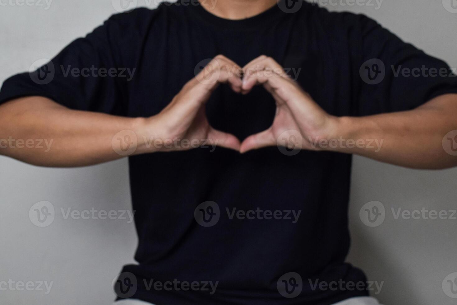 View of Man hand make heart shape gesture for world kindness day or valentine day with little blurry photo