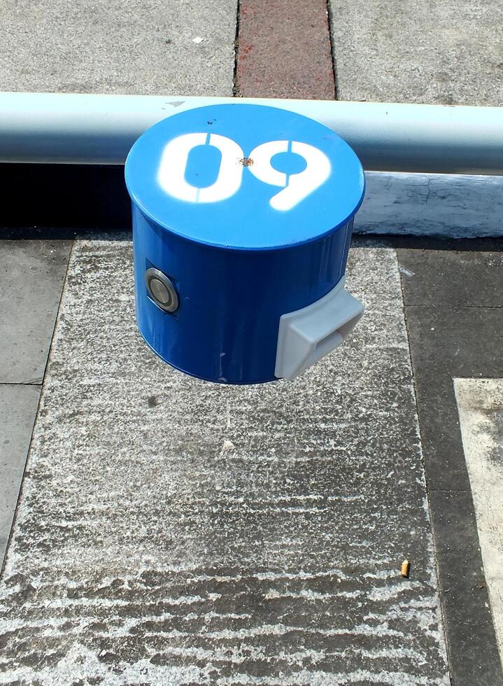 numeric number sign on blue round metal. The numeric is on white color. The object is on an outdoor area. photo