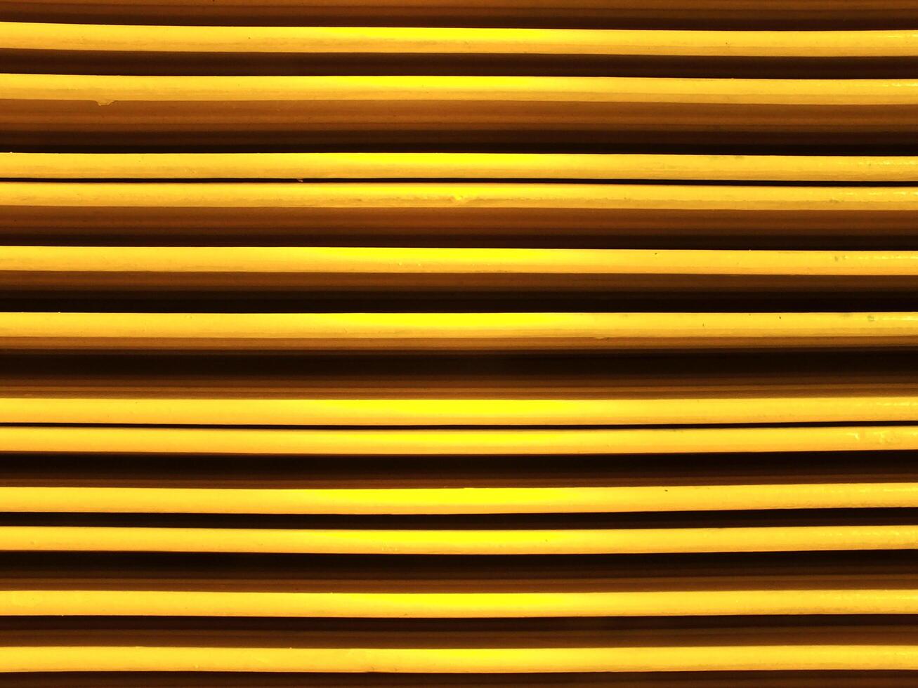 Abstract background image of vibrant color yellow metal sheets. Yellow metal tile fence background. Yellow zinc metal sheet texture. photo