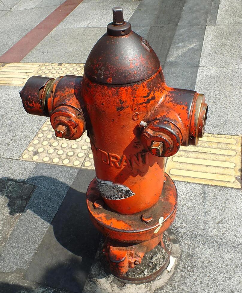 dry hydrants for fire fighting. The hydrant is yellow with some rust and vandalism. public facilities that need maintenance photo