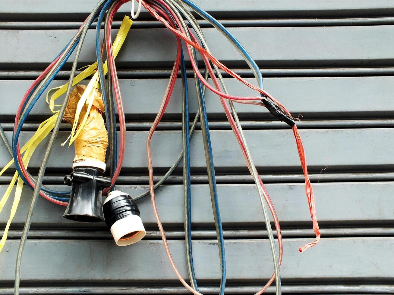 messy electric power cables installation. chaotic network of a tangled electrical wires. Unsightly electric wires on public area causing danger to health and safety. photo