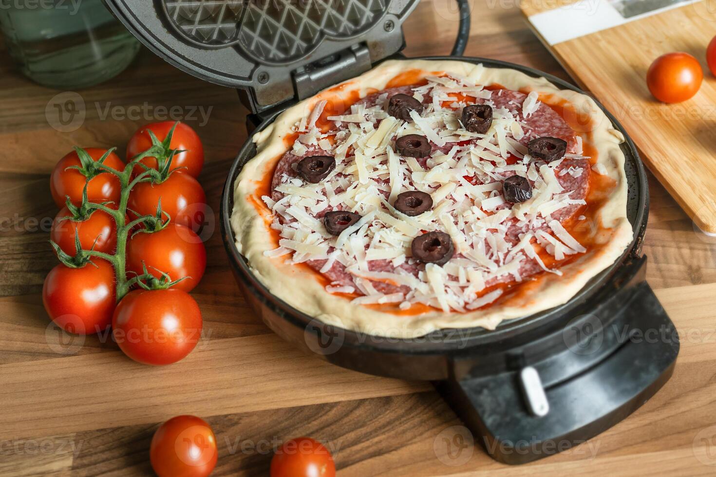 Pizza waffle in a waffle iron photo