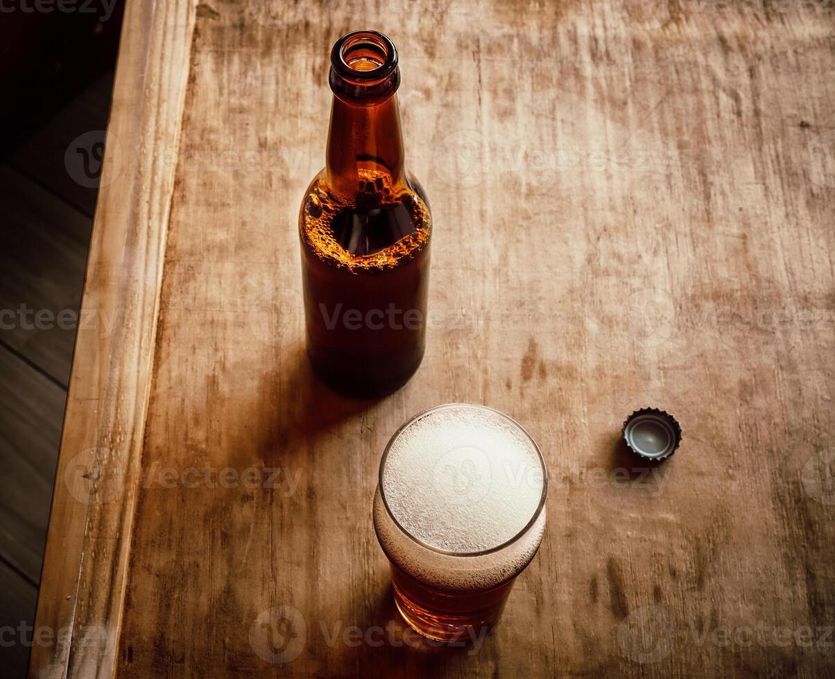 Opened beer bottle, bottle cap and glass with beer photo