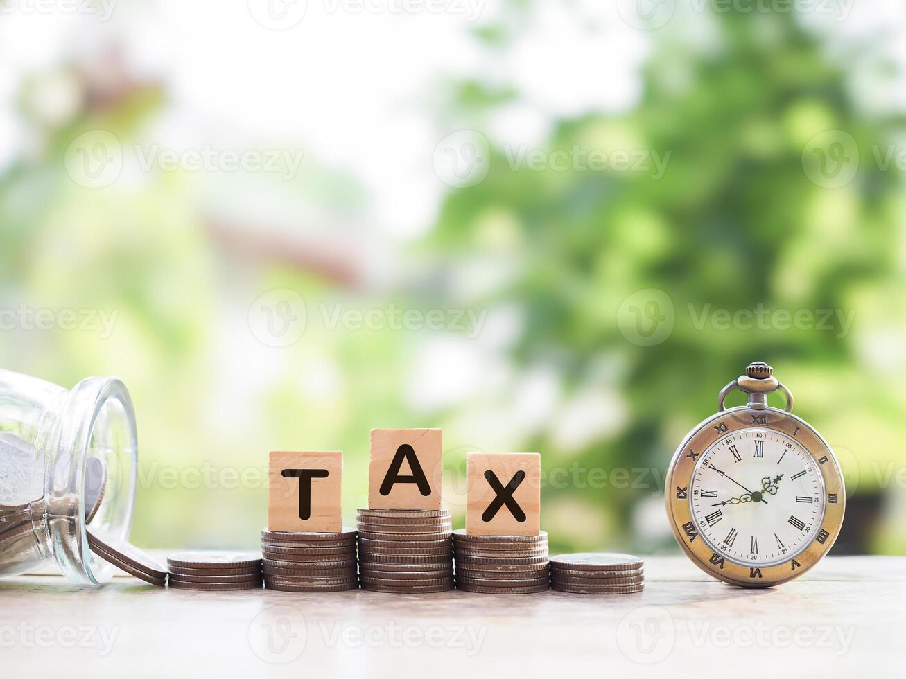 Vintage watch, Wooden blocks with the word TAX on stack of coins. The concept about saving money and manage time to paying tax photo