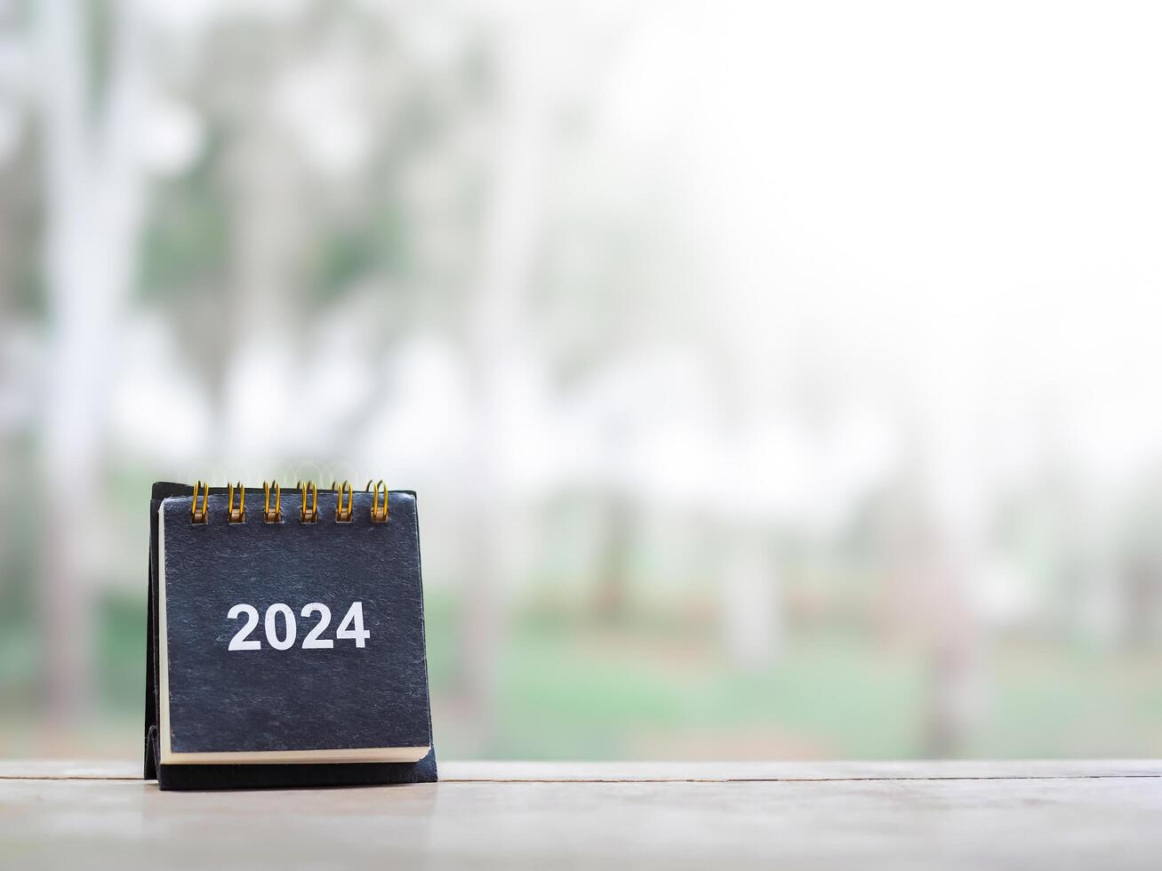 Close up 2024 desk calendar on the table with copy space. Resolution, Goal, Action, Planning, and manage to success business. photo