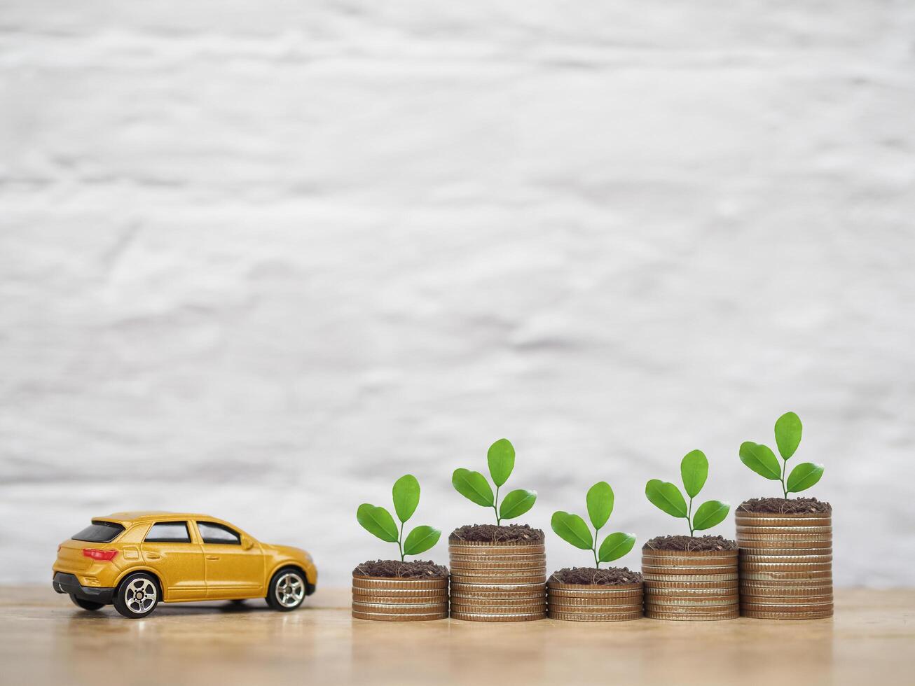 Toy car and plants growing up on stack of coins. The concept of business growth, saving money and manage to success transport business photo