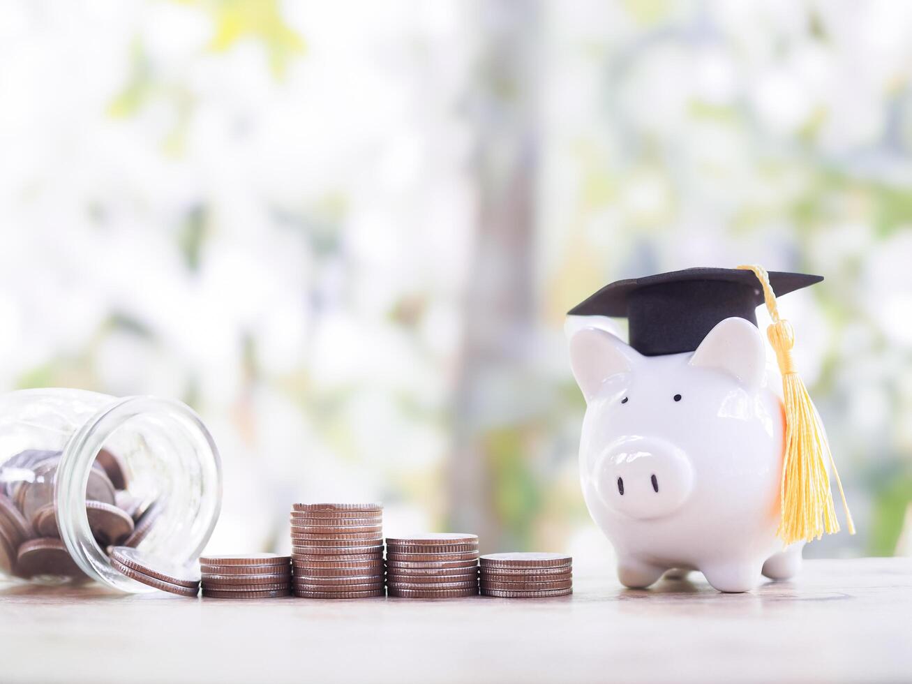 Piggy bank with graduation hat and stack of coins. The concept of saving money for education, student loan, scholarship, tuition fees in the future photo