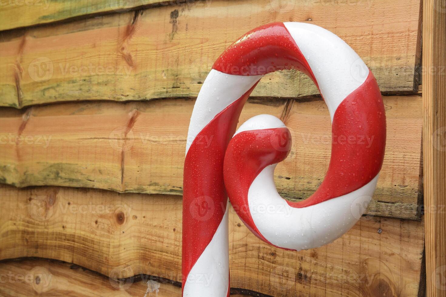 Christmas market decorations. Large Christmas candy cane outdoors in the rain photo