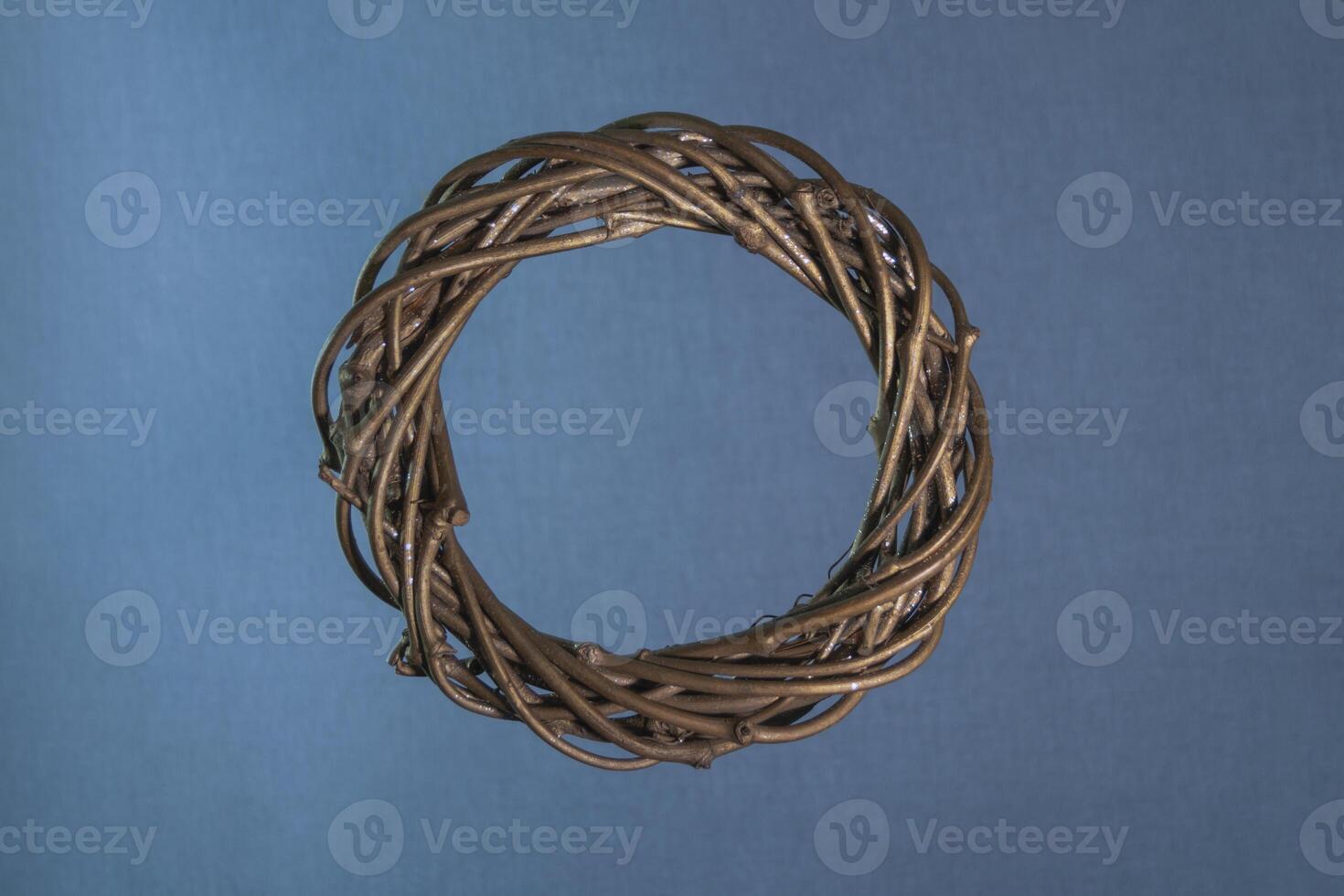 Christmas wreath on a blue-gray background, made of twigs with gilding. Square format. Close-up, texture. photo
