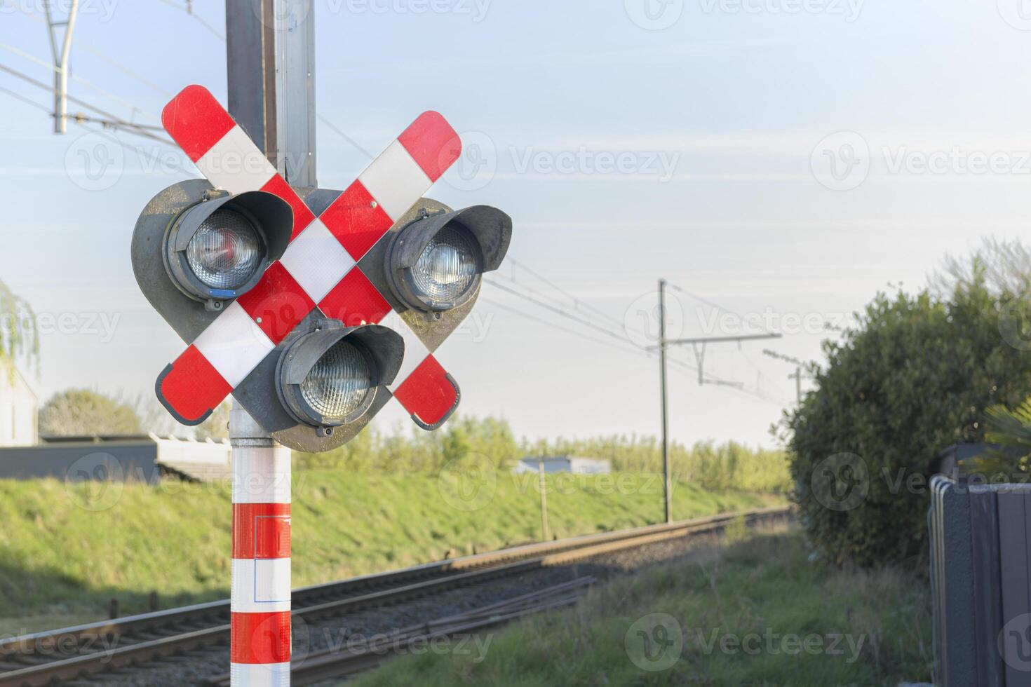 Railway signal light - semaphore and barrier. Railway crossing. Warning road sign about the proximity of a railway crossing. photo