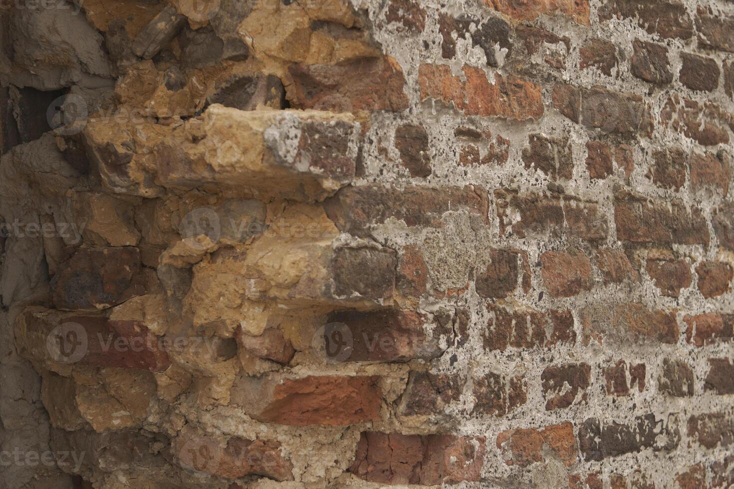 Broken antique brick wall. The structure of a whole and broken brick photo