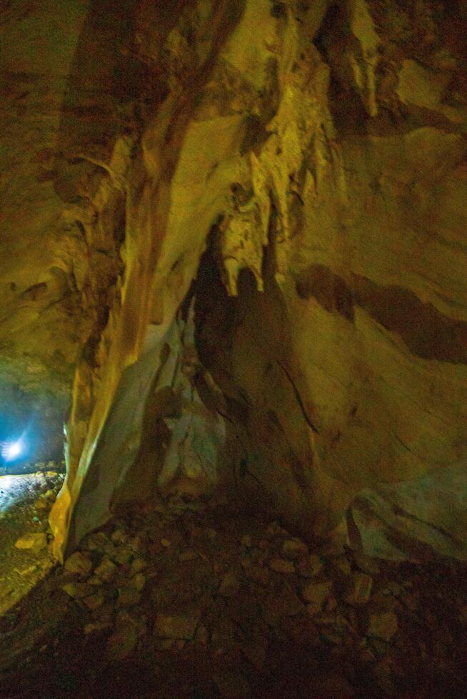 The beautiful views of the stalactite and stalagmite-filled cave in National Park, Thailand. photo