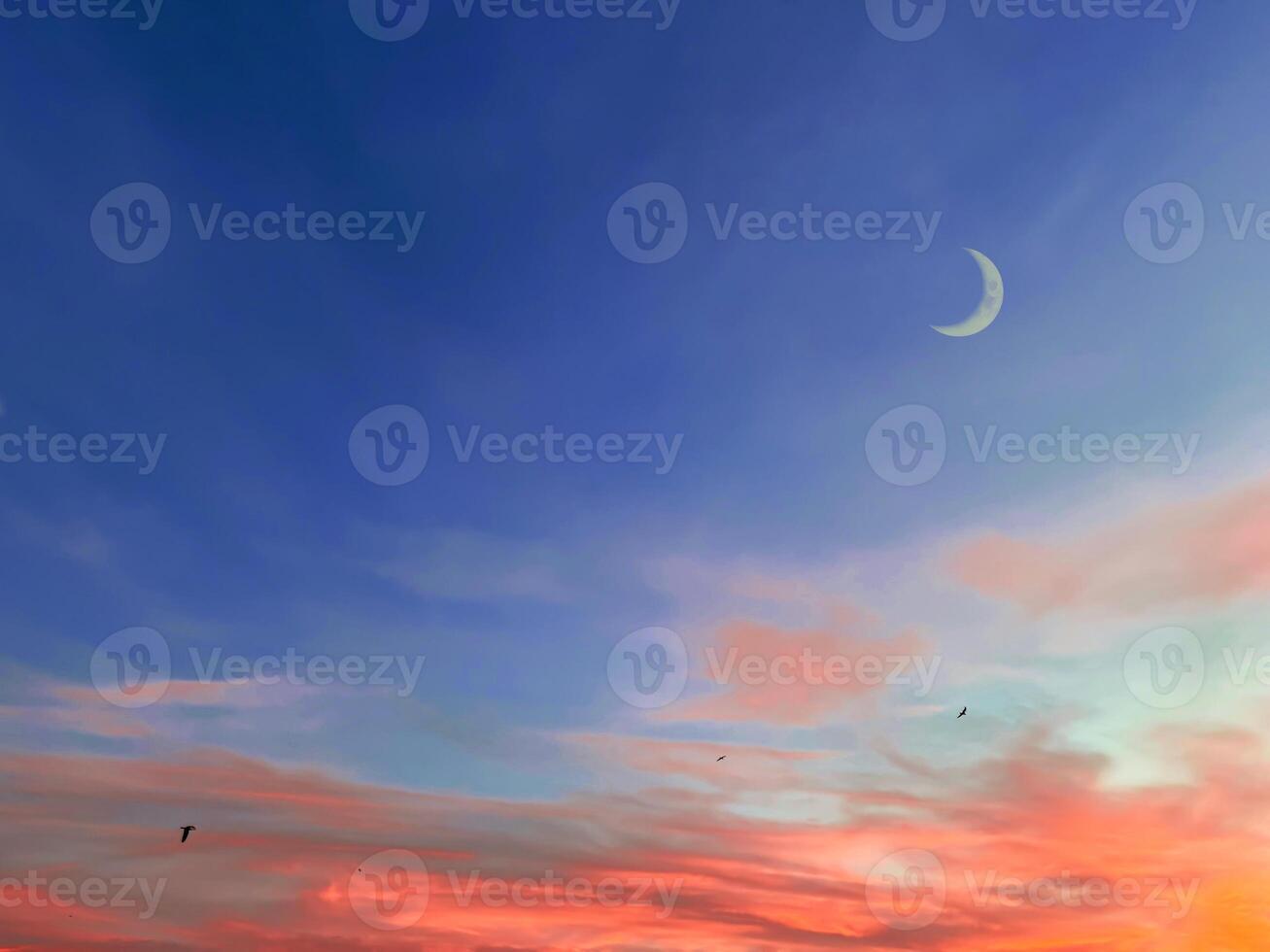 Islamic background with crescent moon in evening with colorful dusk sky. photo