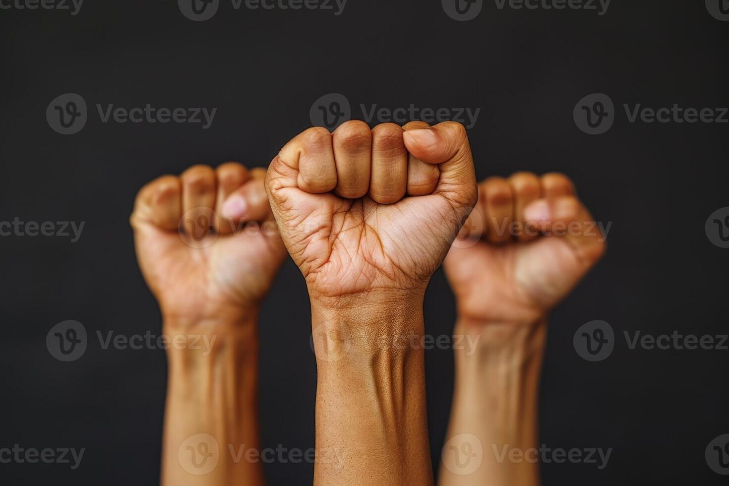 Fists Raised In Unity Against Black Background photo