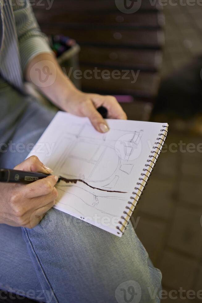 a young artist draws a sketch of a window on the streets of the city photo