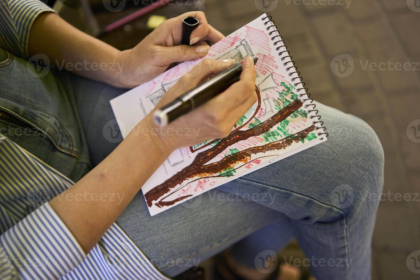 a young artist draws a sketch of a window on the streets of the city photo