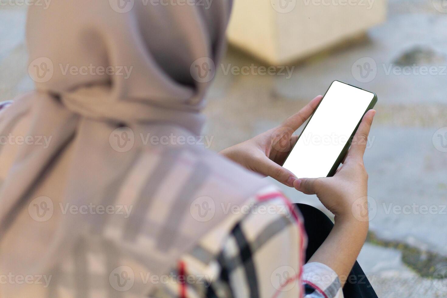 Mockup hijab woman hands holding and using blank screen mobile smart phone clipping path in park outdoor photo