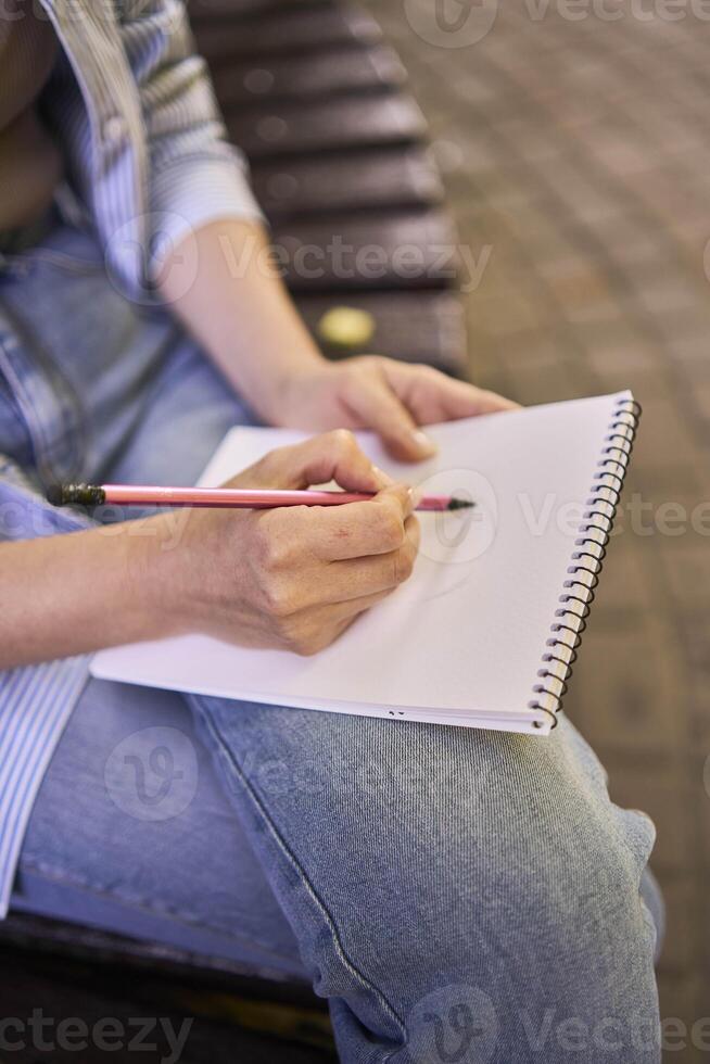 a young artist draws a sketch of a window on the streets of the city photo