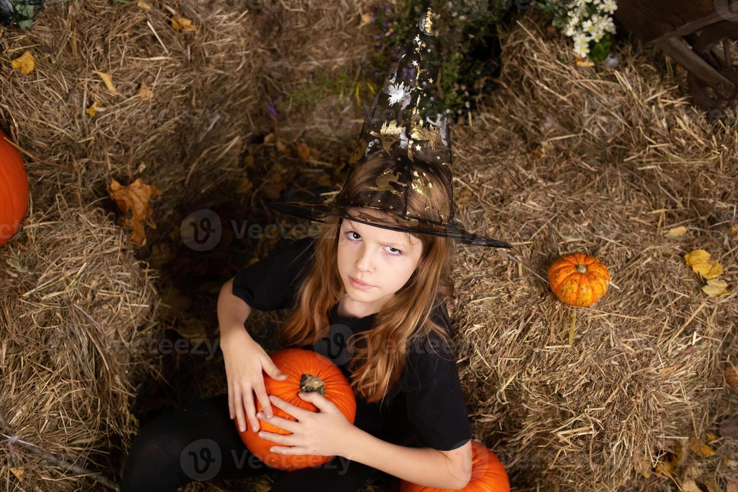portreit happy girl on Halloween. Funny children in carnival costumes indoors. Cheerful children play with pumpkins and sweets photo