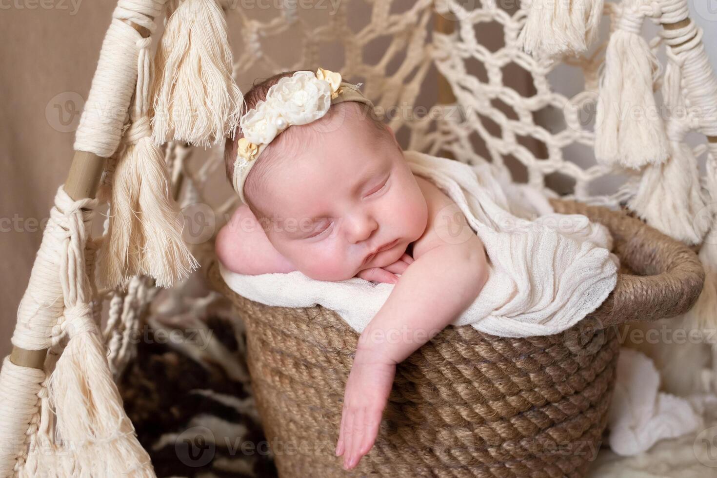 a beautiful baby sleeps in a wicker basket that stands in a wicker tent. beige background with space for text with baby sleeping in a wicker basket. close-up portrait photo