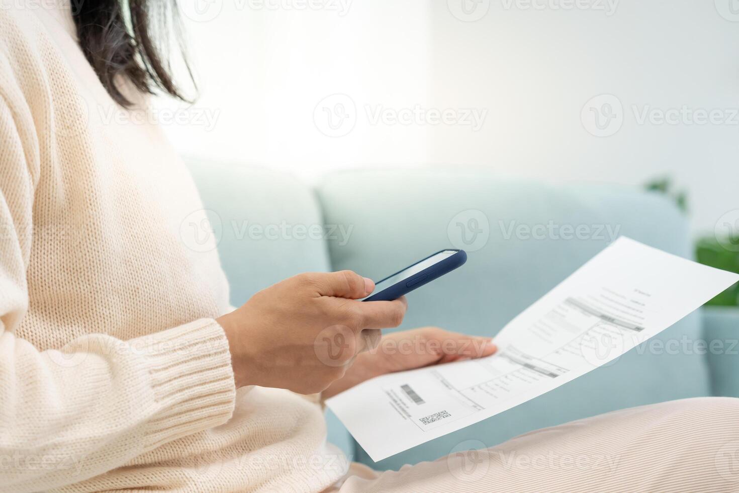 woman use phone scan barcode or QR codes to pay credit card bill after receiving document invoice. payment, receive, paying electricity, digital payments, technology, scanning, financial transactions photo