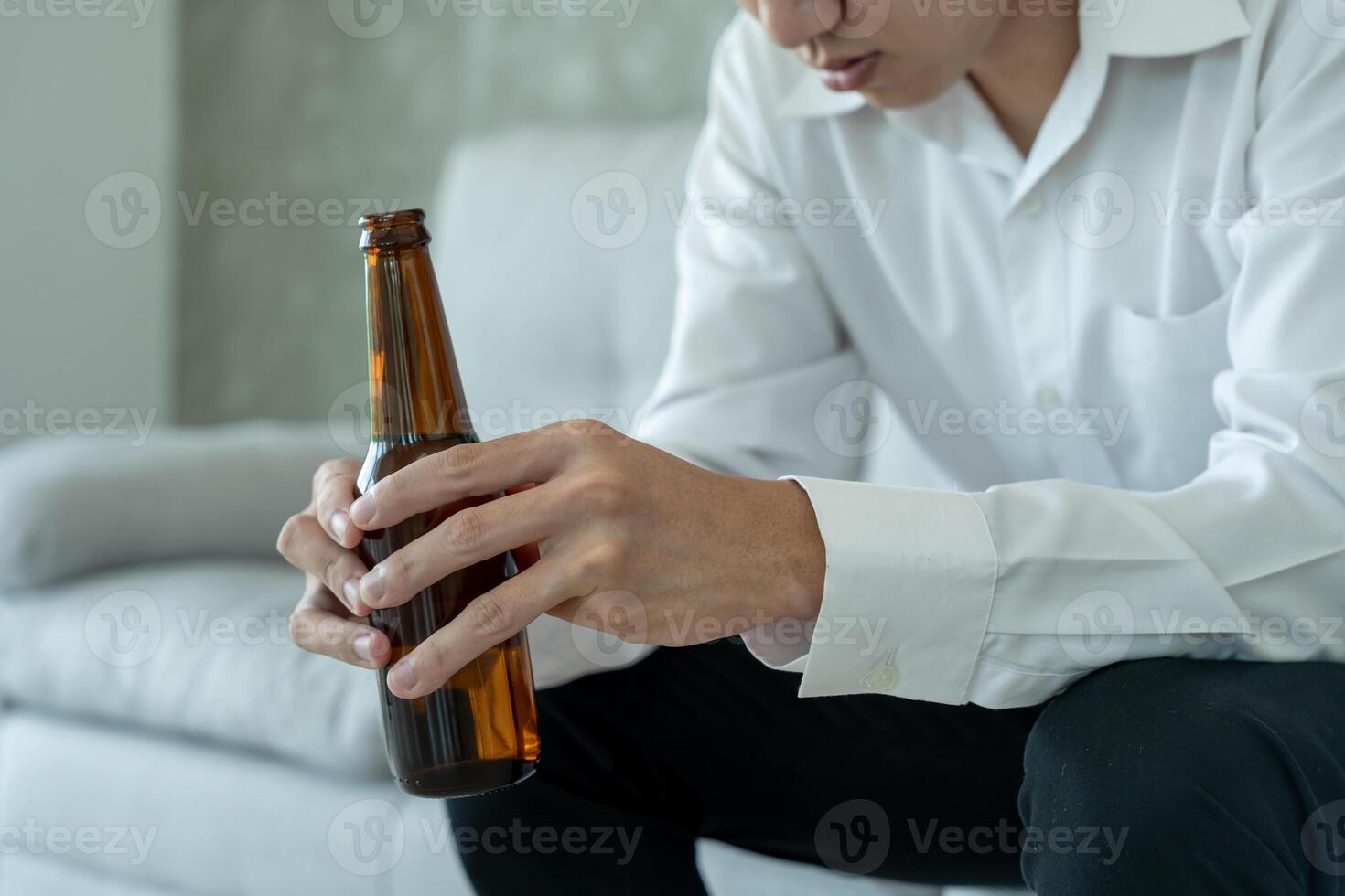 Depressed young business man addicted feeling bad drinking whiskey alone at home, stressed frustrated lonely drinking alcohol suffers from problematic liquor, alcoholism, life and family problems photo