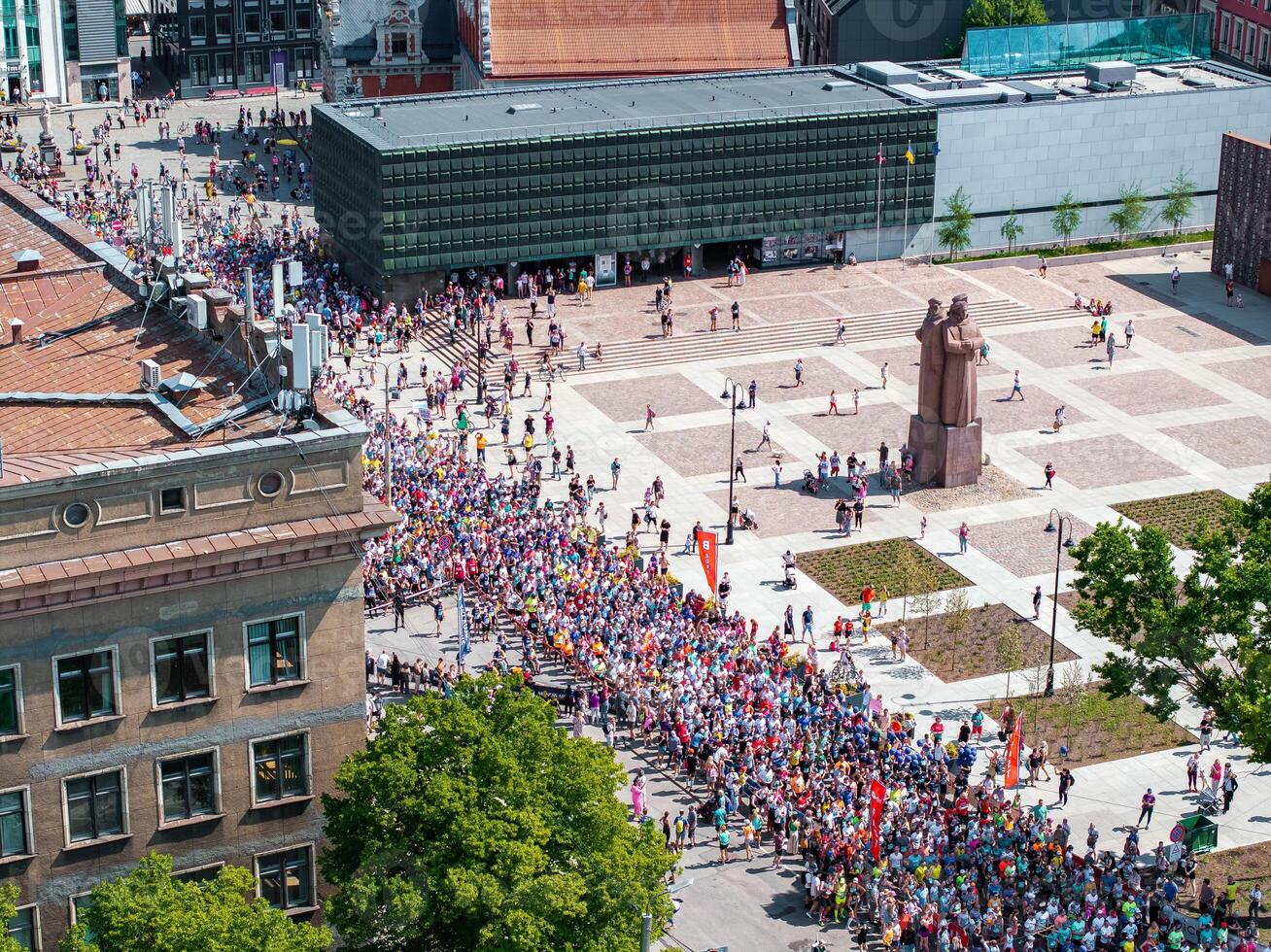 Aerial View of Runners in City Square with Green Roof Building and Statue photo