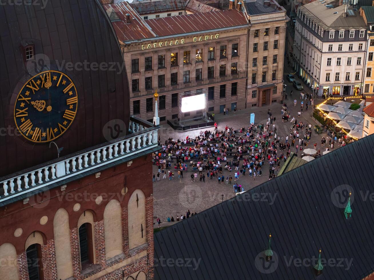 Aerial View of Crowd Gathered in City Square with Prominent Clock Tower photo