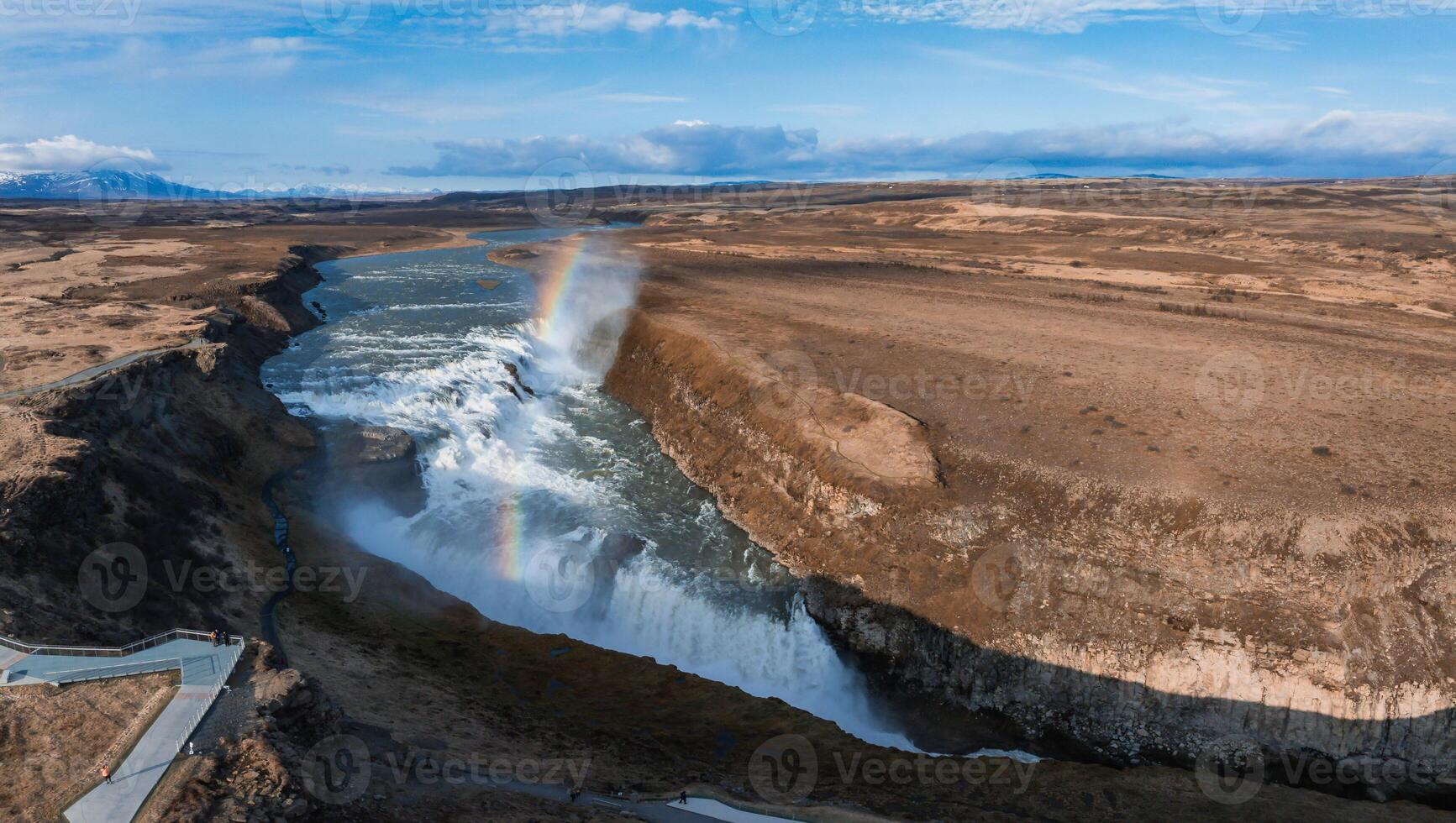 Aerial View of Gullfoss Waterfall with Rainbow in Rocky Icelandic Landscape photo