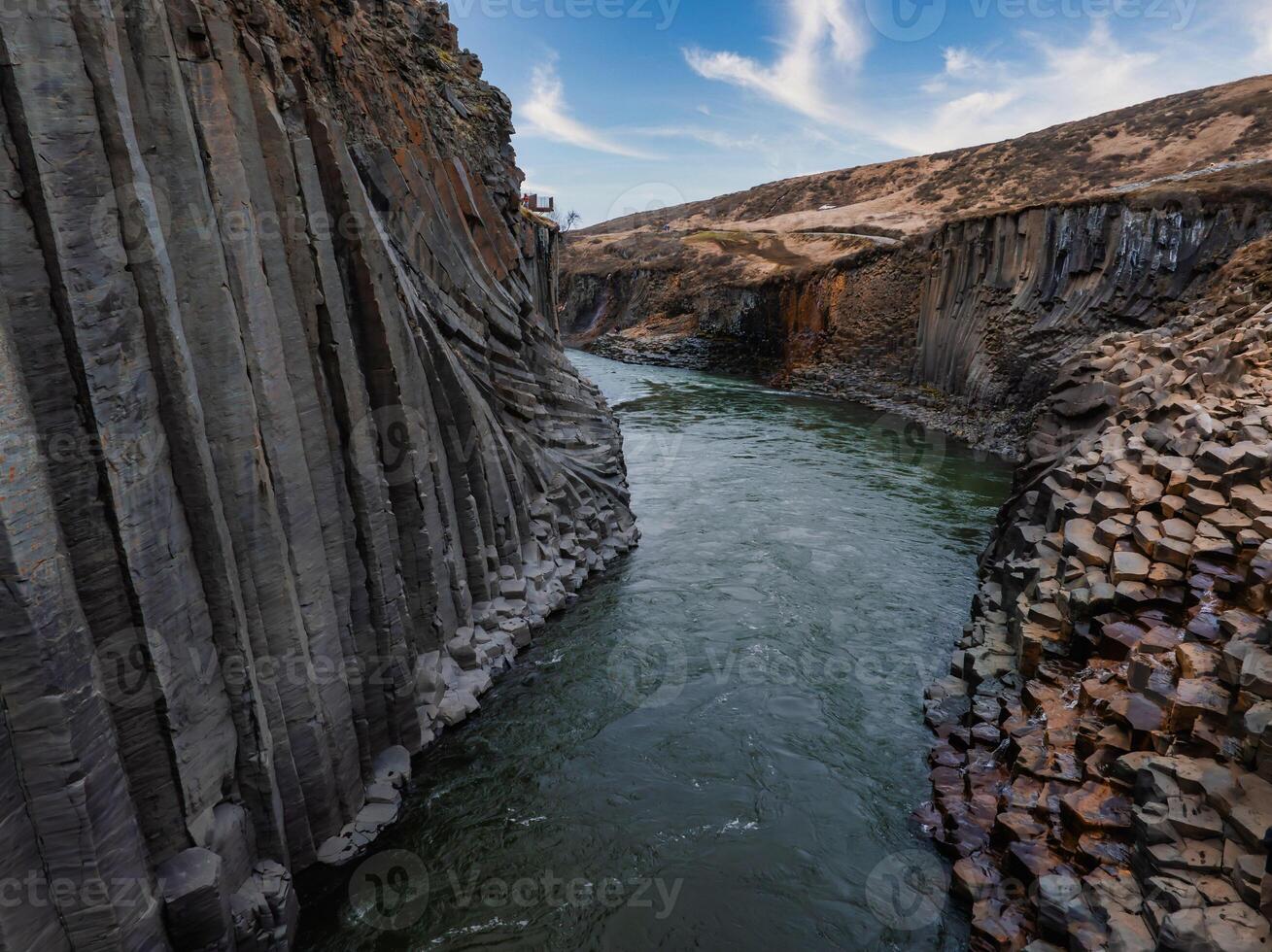 Aerial View of River Flowing Through Basalt Cliffs in Icelandic Canyon photo