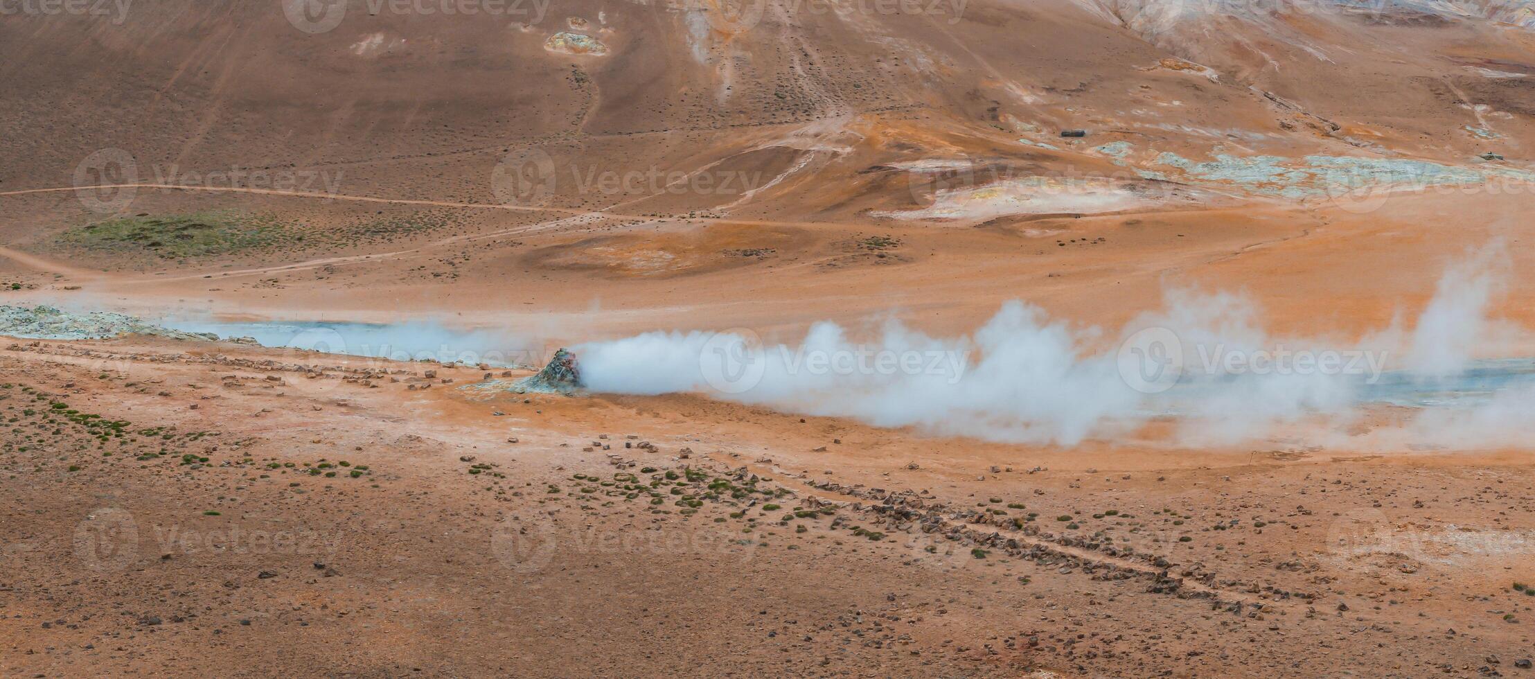 Aerial View of Erupting Geyser in Iceland's Rocky Landscape photo
