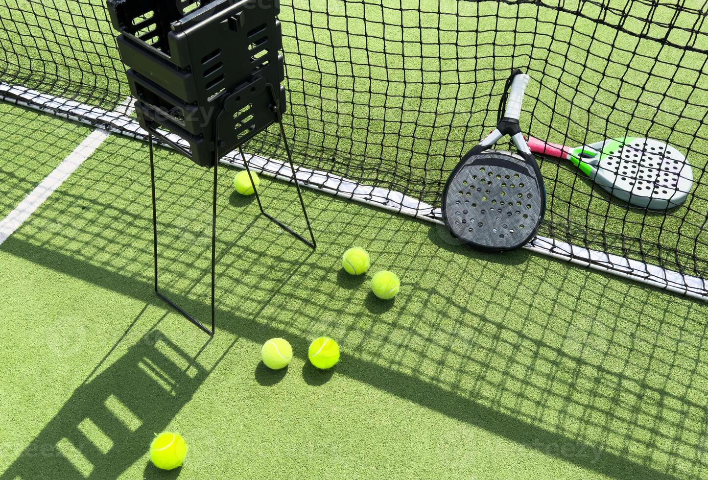 Paddle tennis racket, ball and net on the grass photo