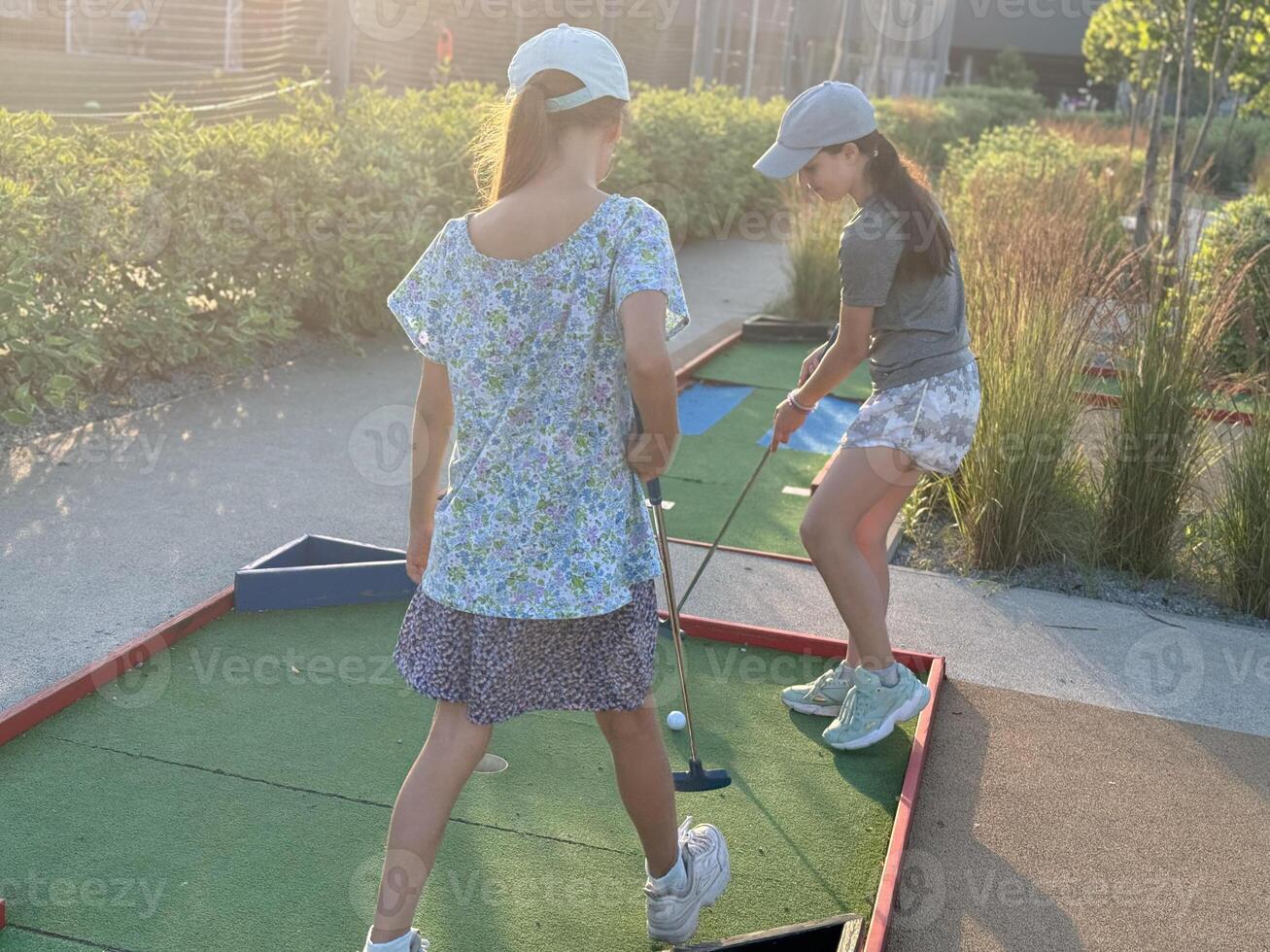 teenage girls play mini golf photo
