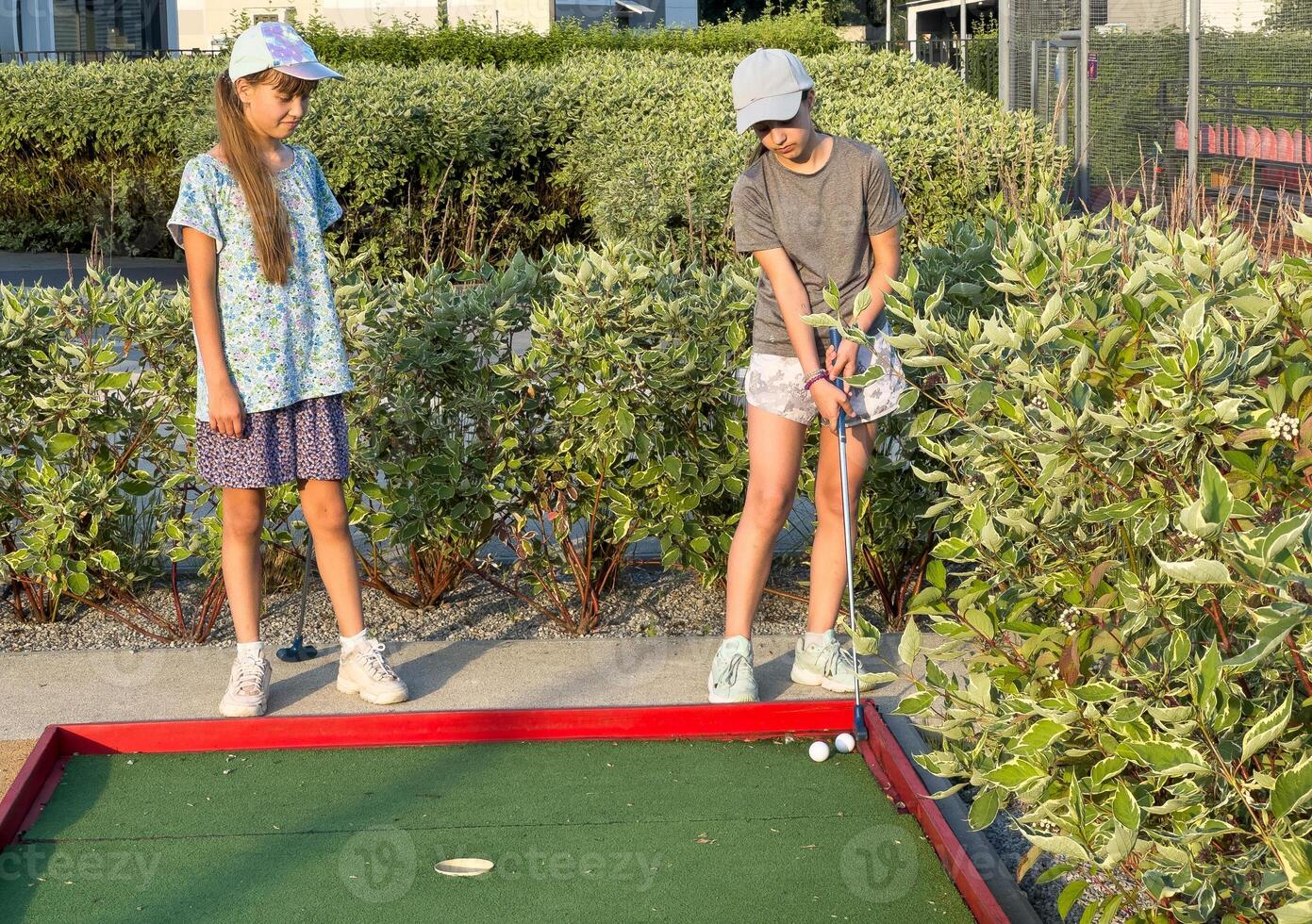 teenage girls play mini golf photo