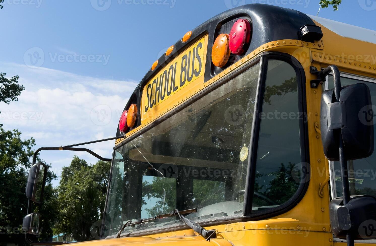 Shot of retro-styled yellow school bus with extended red stop sign standing still on serene road, empty vehicle with no driver awaiting children to boarding, transportation concept, copy space photo