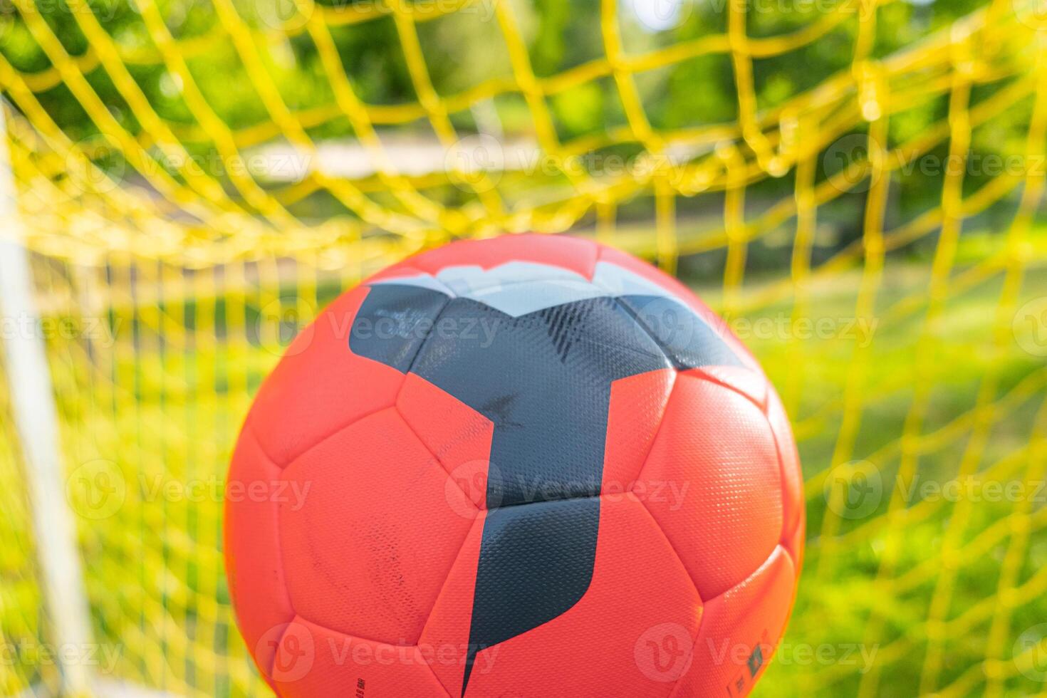 red ball in the soccer goal of a football field photo