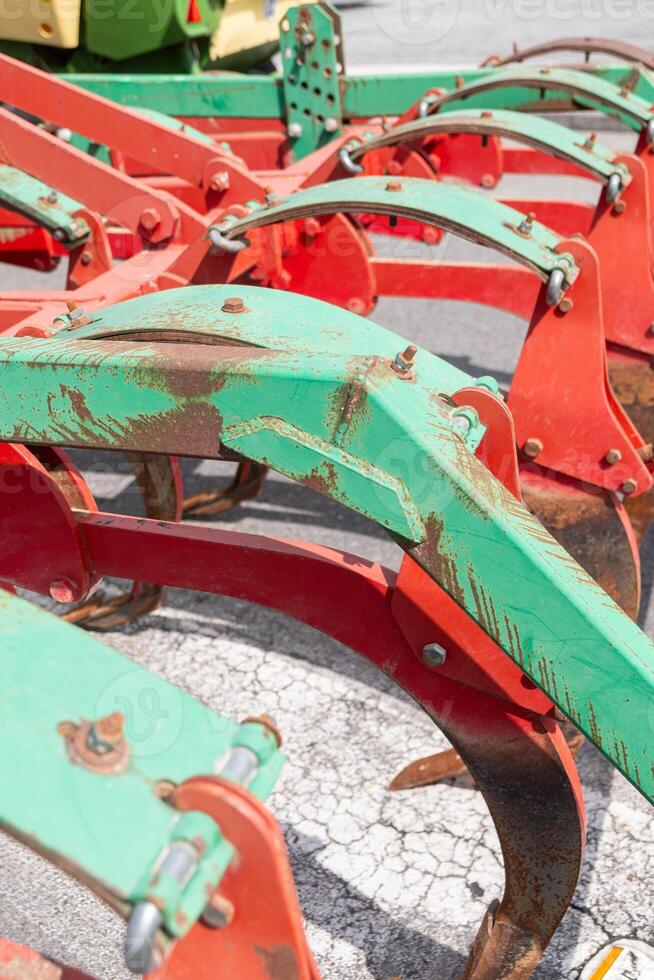 detail of a plow painted in rusty red and green, agricultural machinery photo