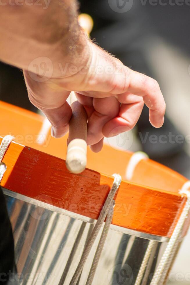 close up detail of a man's hand playing a drum in a traditional music event of folk music photo