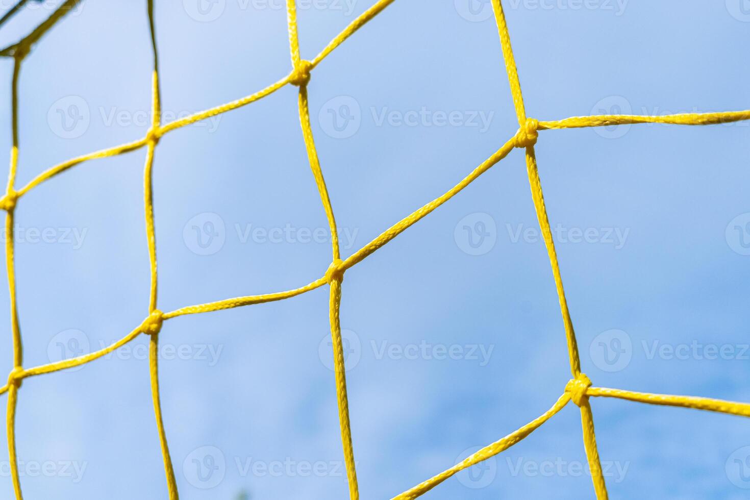 net of a yellow soccer goal with blue sky in the background photo