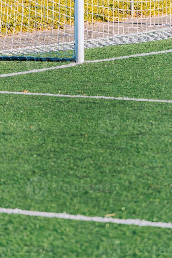 partial view of goal in a green synthetic grass surface on a soccer field. European football field, artificial grass photo