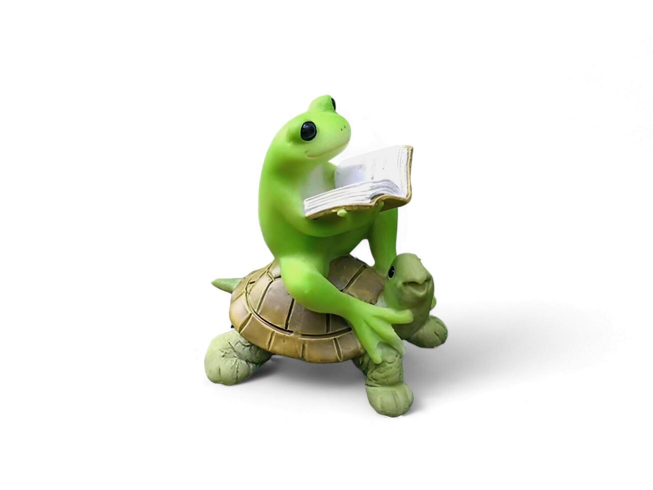 Decorated miniature frog sitting on a turtle and reading a book on a white background photo