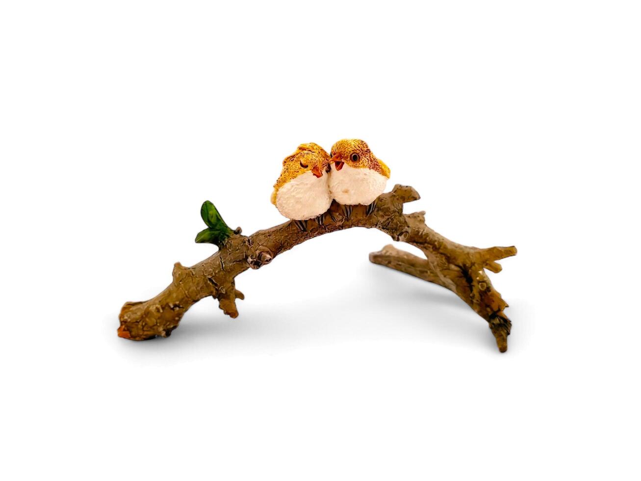 Miniature animals of a pair of birds on a twig on a white background photo