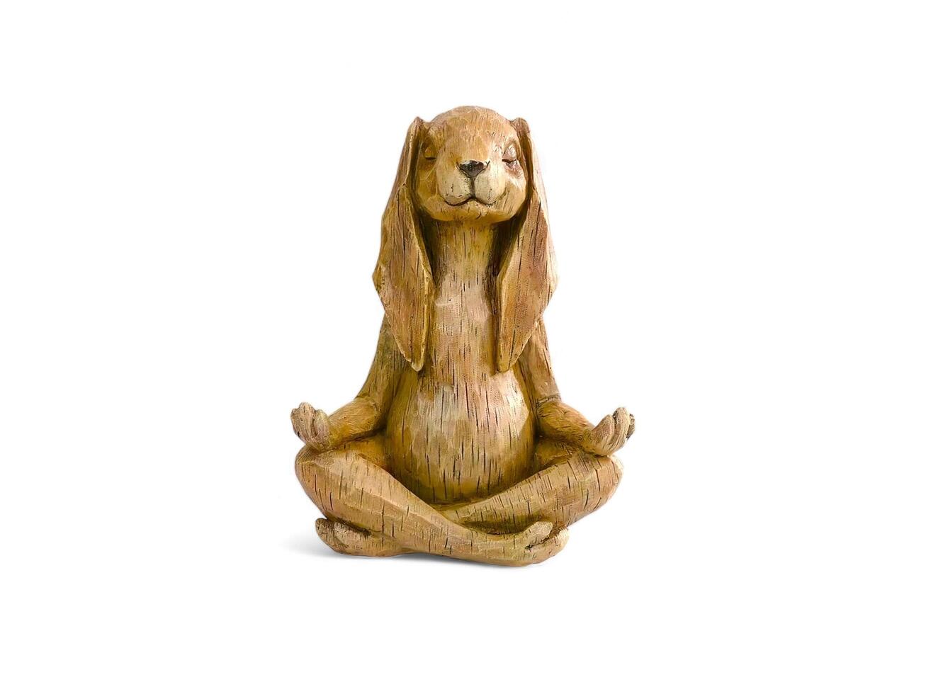 figurine of a meditating abbit made of wood isolated on white photo