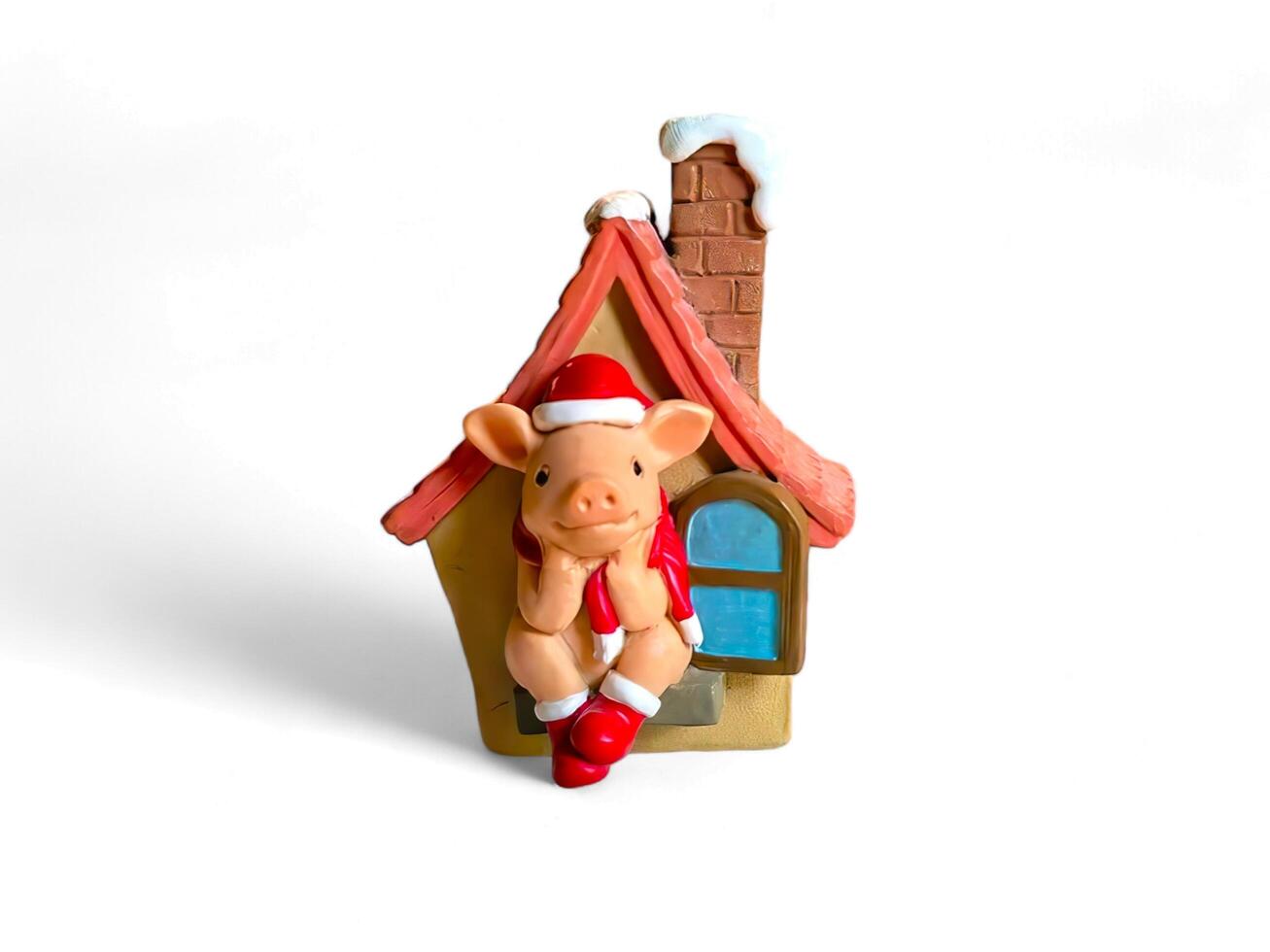 Miniature Christmas ornaments of houses and pigs on a white background photo