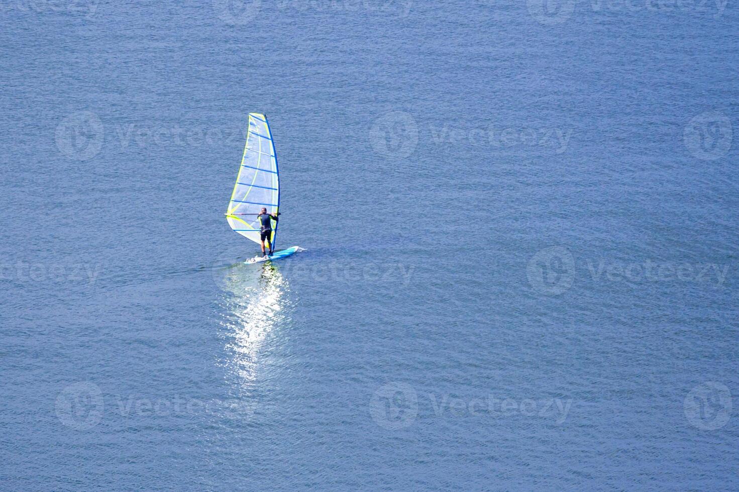 View on a windsurfer with reflection in the water photo