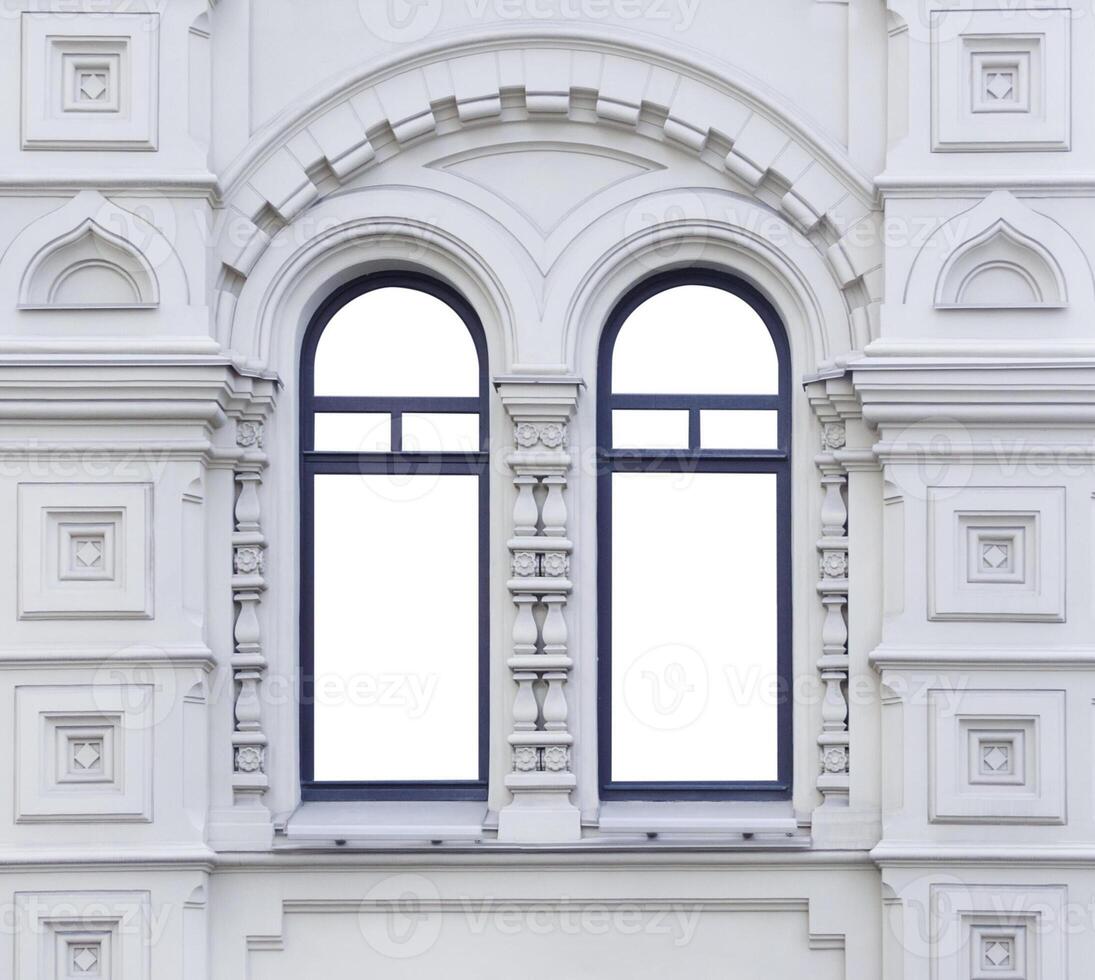 Close up view on a facade of white ancient building with two-part isolated arched windows photo