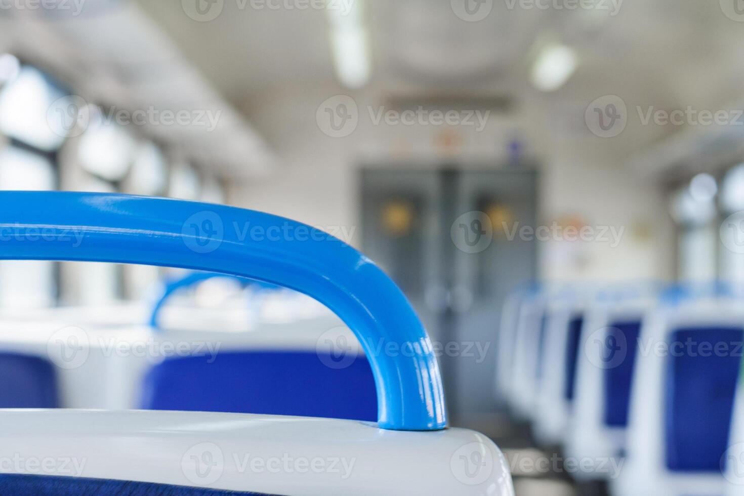 Close up view on a blue handhold on a background of Interior of a passenger train in blur photo