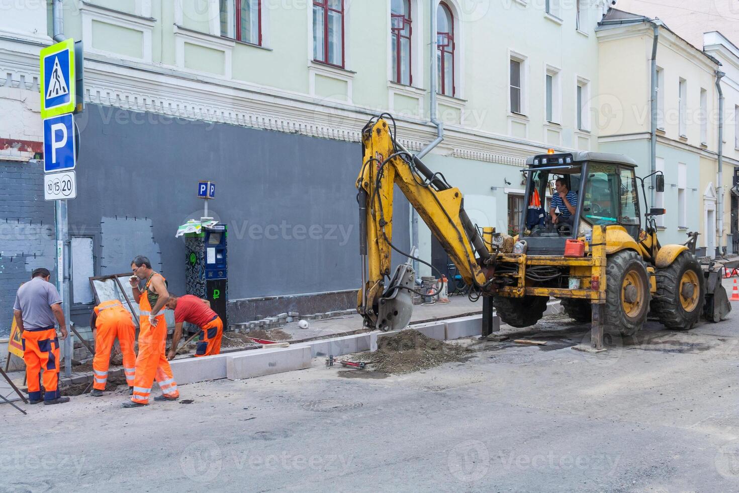Moscow, Russia, August 2018 Working team change curbstones with an excavator. Road works on the city street photo
