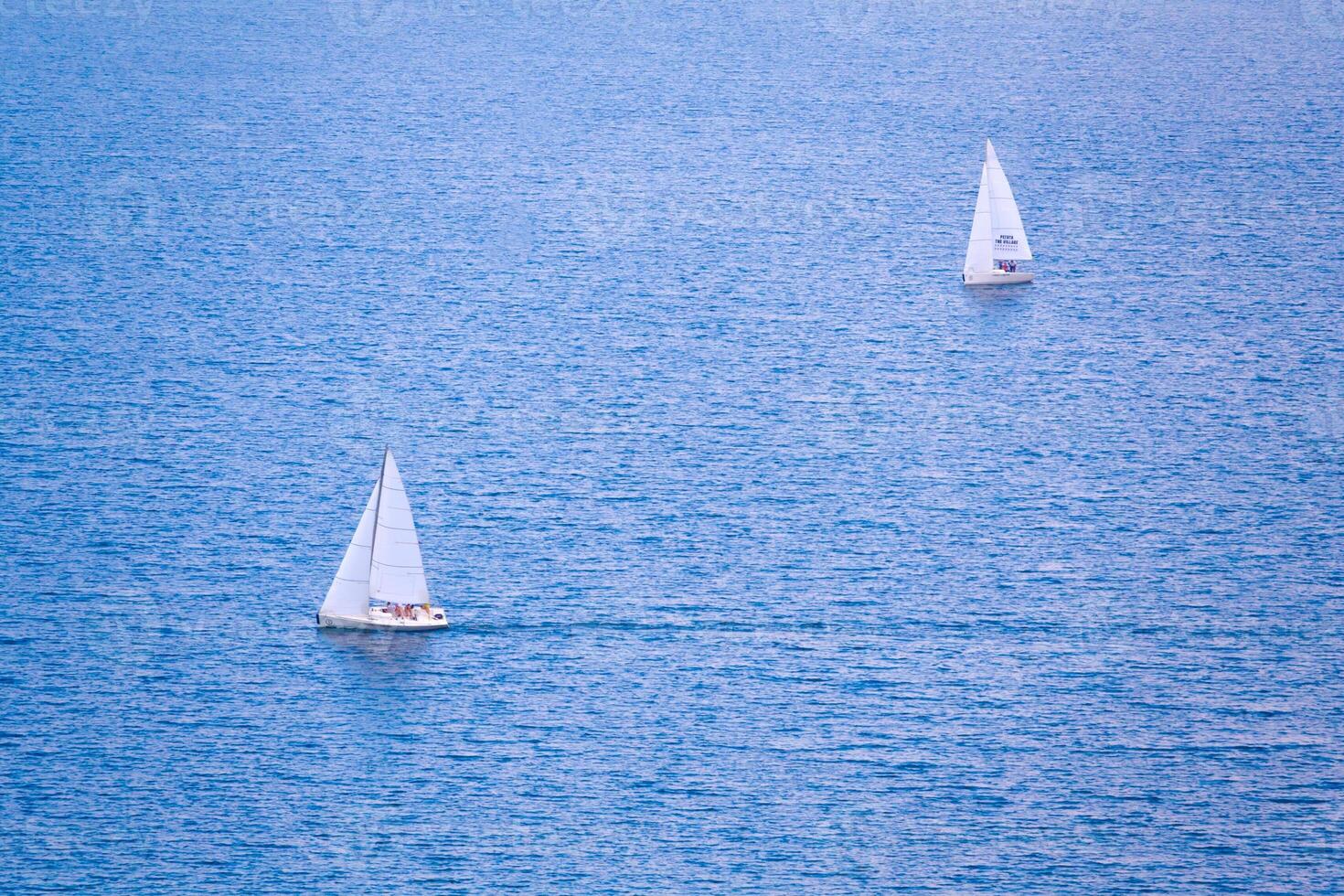 Two sailing boats on the blue water photo